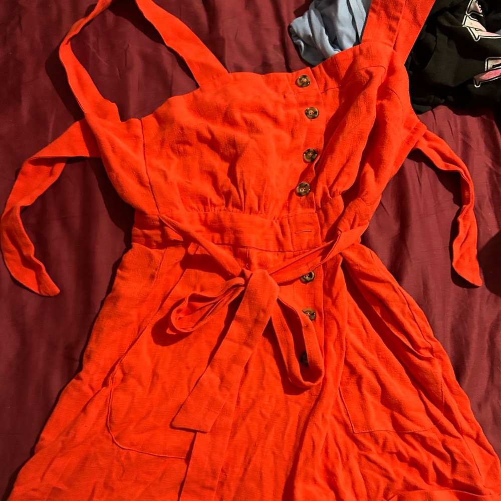 cute orange jumper with buttonsdown the front and a tie in the wasteCutepockets